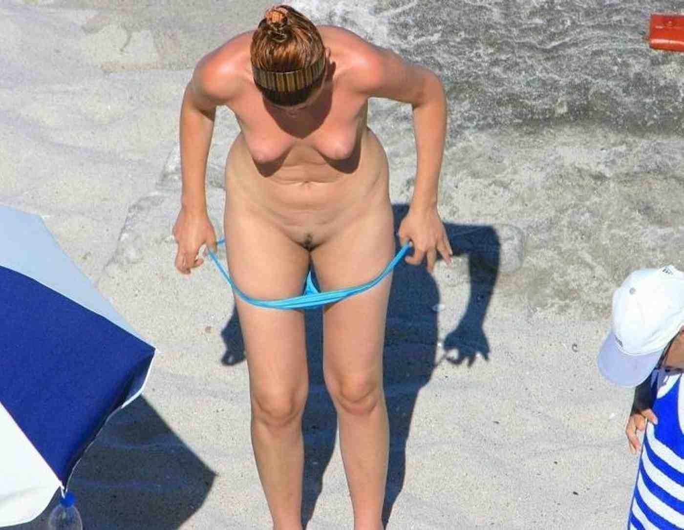 Женщина с бритым лобком переодевается на пляже