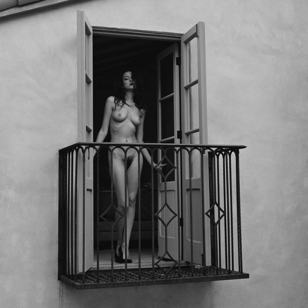 The girl undresses on the balcony