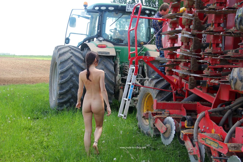Naked on the background of the tractor