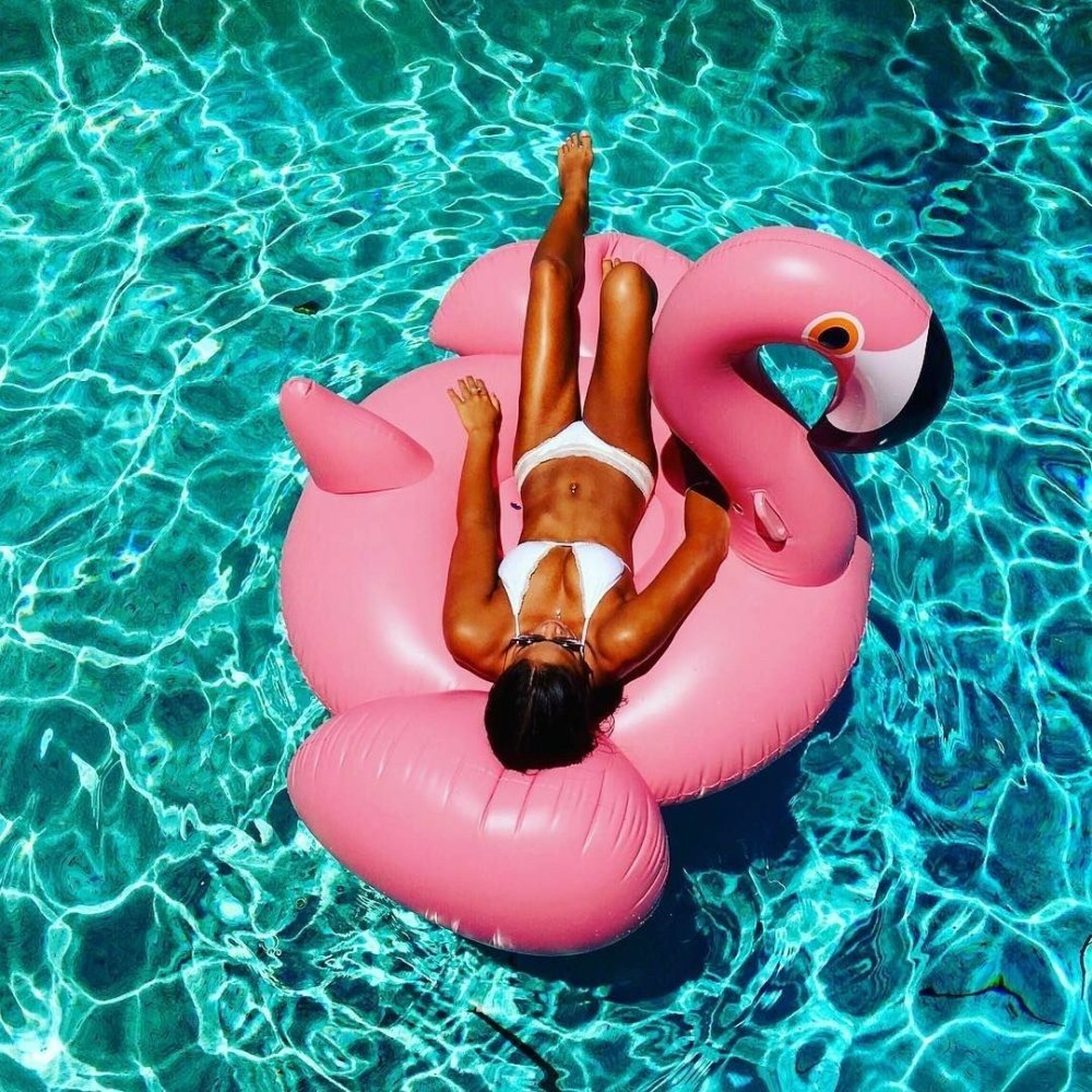 Tanned girls with inflatable flamingos
