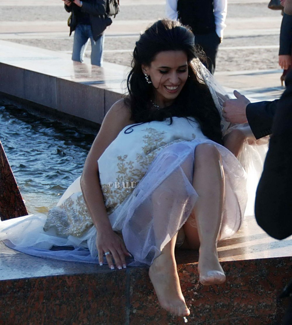 Bride in stockings in the fountain