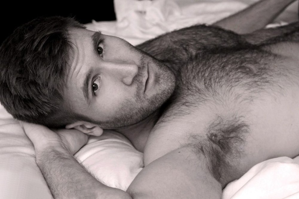 The guy lies on a guy's hairy chest