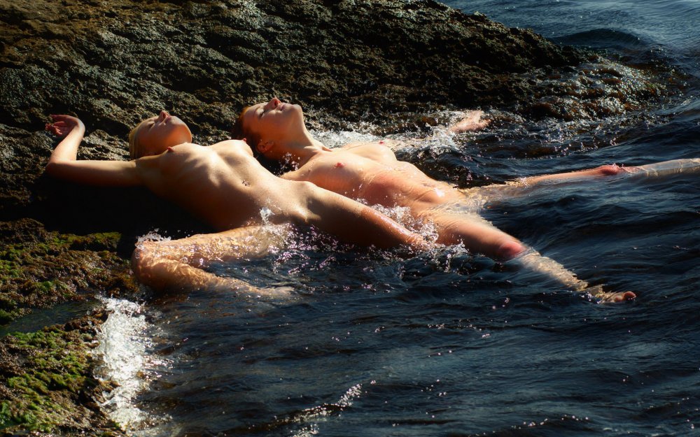 Naked women and guy in water