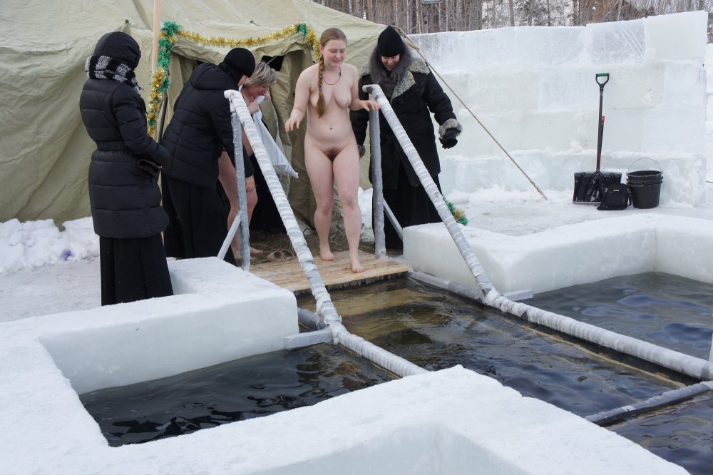 Naked women bathe in a hole