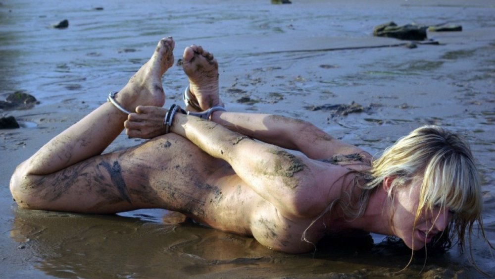 Naked woman in mud bath