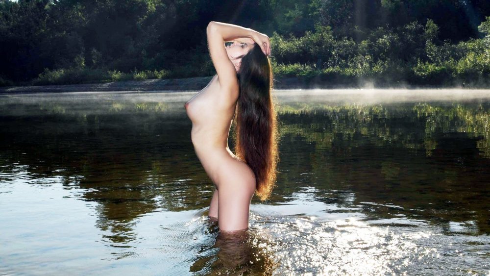 Slender brunette in the water naked
