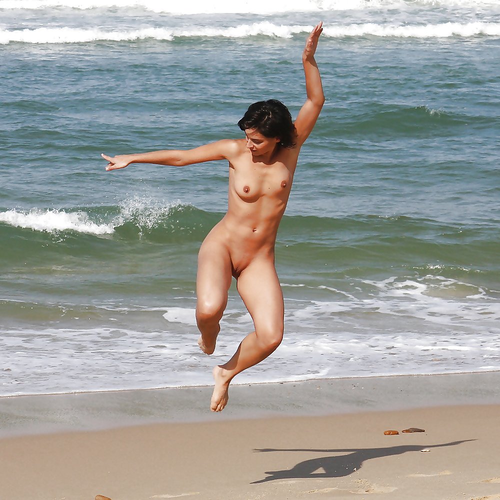 Naked girls run along the beach