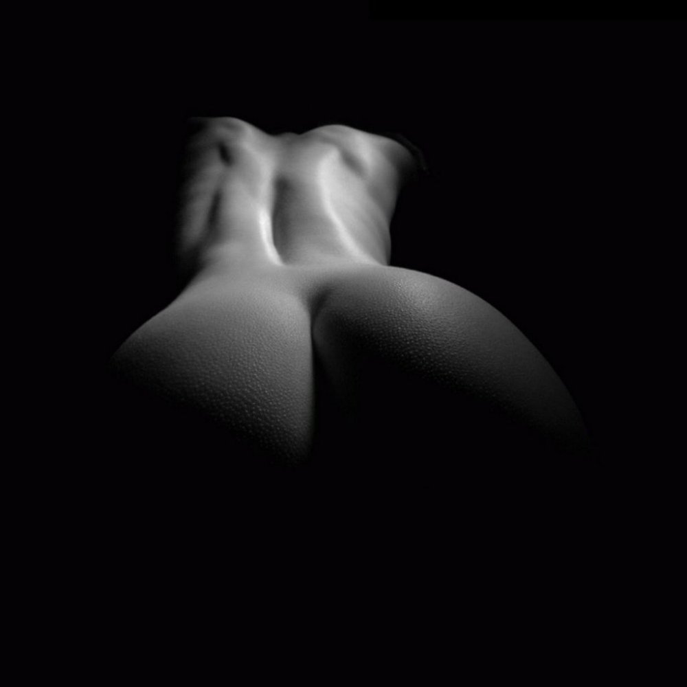 A naked woman in the dark lies