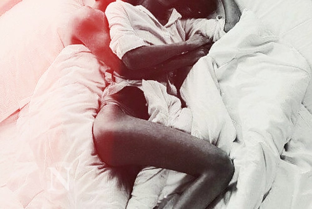 The couple hugs in bed