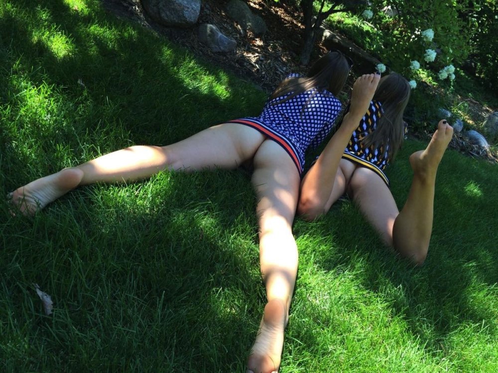 Lies on the grass in a skirt without panties