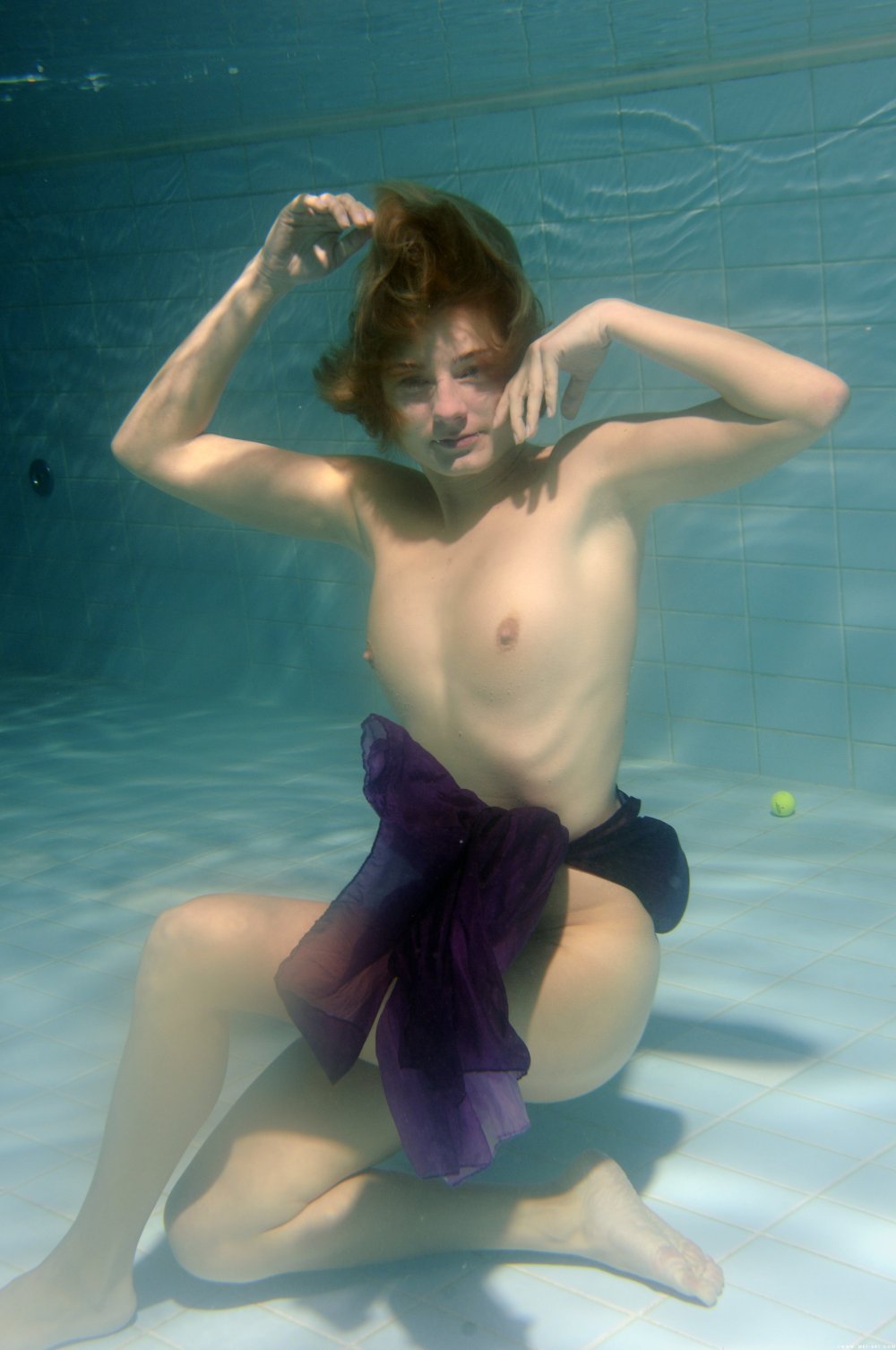 The girl undresses under water