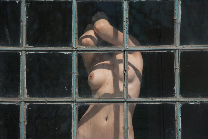 Naked woman in the window on contrary