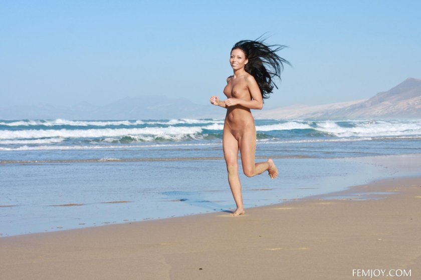 Naked girls run along the beach