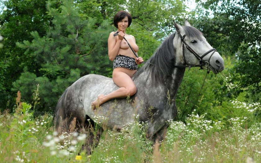Naked woman riding a horse