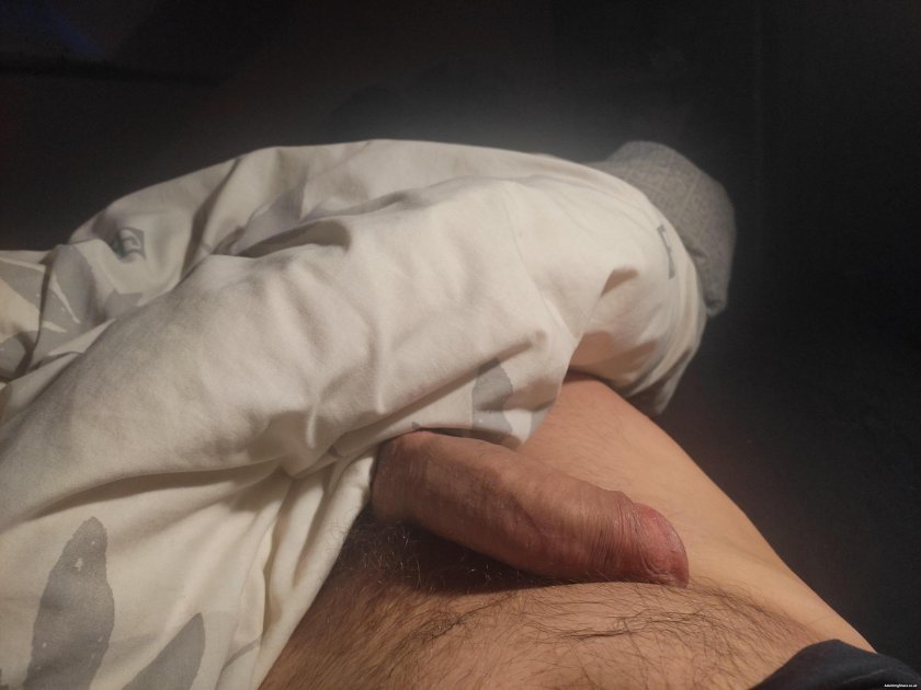 Standing member in shorts under the covers